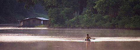 Floating house and man in canoe Mamirau‡, Amazonia, Brazil / ©: Roger Leguen / WWF - Canon rel=