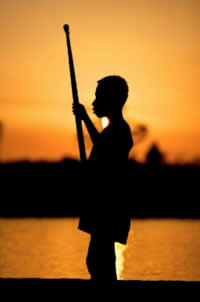 Young boy in traditional dug-out canoe, near Bensbach tourist lodge, as sun sets over the Bensbach ... / ©: Brent Stirton/Getty Images / WWF-UK / ©: Brent Stirton/Getty Images / WWF-UK