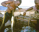WWF project worker weighing fish catch, Mafia Island, Tanzania.