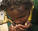 Girl drinking water from a city tap, Nairobi, Kenya.