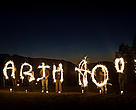 A group of people spelling out Earth Hour with sparklers against a dark sky on Vancouver Island, Earth Hour 2010, Canada.