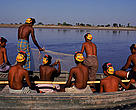 Fishermen wearing masks to protect from tiger (<i>Panthera tigris</i>) attack. Tigers attack by biting back of neck, mask with prominent eyes intended to mislead and prevent tiger from attacking from rear. Sunderband, W Bengal, India.