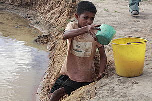 A little boy in a watering hole / &copy;: Malika Virah-Sawmy