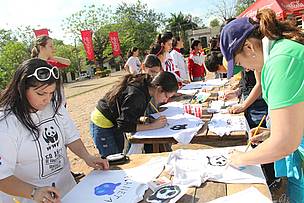 Participantes del evento pintando sus remeras con mensajes alegoicos al día.