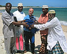 Dr kwame Koranteng (left), WWF EARPO regional representative, presents sustainable fishing gear to local fishermen living around Kiunga Marine Reserve.