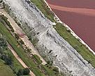 A June 2010 aerial photograph of the wall of the Kolontar sludge reservoir clearly shows damage and leakage - three months before dam walls breached, killing seven, covering 40 sq km with toxic red sludge and sending a plume of caustic pollution down rivers into the Danube.