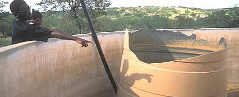 Bob Guibeb of the Khoadi Hoas Conservancy surveys damage to a container that collects rainwater for ... / ©: WWF-Canon / Jan Vertefeuille Bob Guibeb of the Khoadi Hoas Conservancy surveys damage to a container that collects rainwater for ... rel=