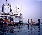  A large Spnaish trawler floats in stark contrast to the local fishermen's boat, Senegal. / &copy;: WWF-Canon / Jo Benn