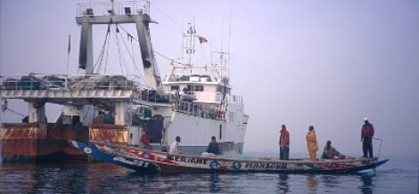 Artisanal pirogue with local fishermen passing Spanish trawler in their fishing grounds. Senegal. / ©: WWF-Canon / Jo BENN rel=