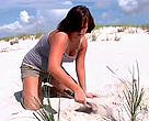 A student from the WWF Allianz Southeast Climate Witness project plants trees on the beach.